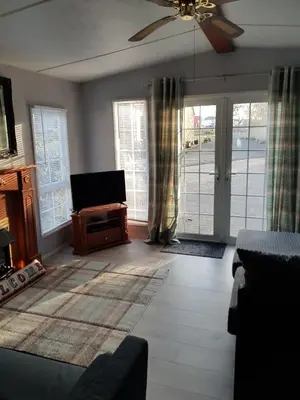 a living room with a ceiling fan and sliding glass doors at Rooms at Tarrareoch in Bathgate