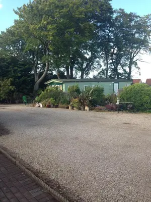 a green building with trees in the background at Rooms at Tarrareoch in Bathgate