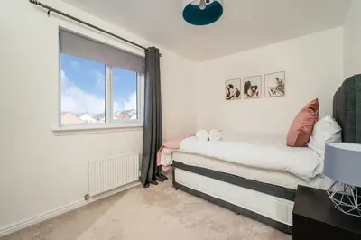 a bedroom with a bed and a window at Modern 3-Bed Family Home Near Glasgow Airport in Bishopton