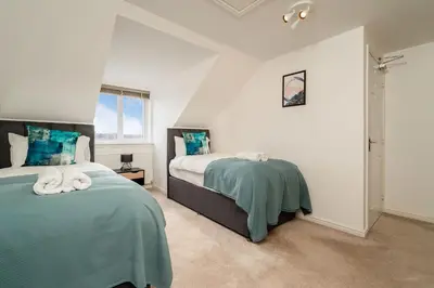 a bedroom with two beds and a window at Modern 3-Bed Family Home Near Glasgow Airport in Bishopton