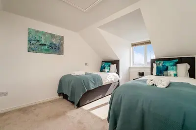 a bedroom with two beds and a window at Modern 3-Bed Family Home Near Glasgow Airport in Bishopton
