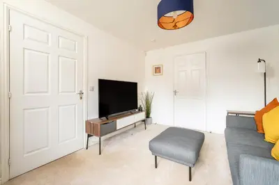 a living room with a flat screen tv and a couch at Modern 3-Bed Family Home Near Glasgow Airport in Bishopton