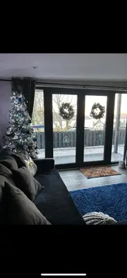 a living room with a christmas tree and a couch at Little bay cabin in Oban