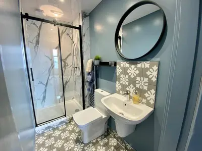 a bathroom with a toilet and a sink and a mirror at Westbay Seafront Apartment in Oban