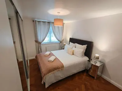 a small bedroom with a bed with a window at Lovely 2 Bedroom Modern Ground Floor Flat in Clydebank