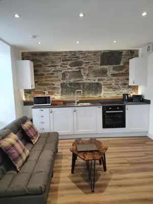 a living room with a couch and a kitchen at Craiglea Thistle in Killin