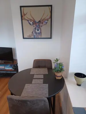 a dining room table with chairs and a picture of a deer at Craiglea Thistle in Killin