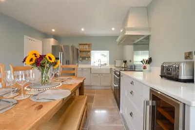 a kitchen with a table with a vase of flowers on it at Achanlochan Farm in Taynuilt