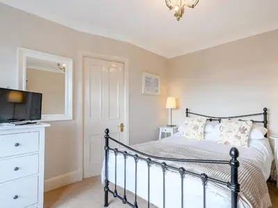 a bedroom with a bed with a tv on a dresser at The Bield in Aberfoyle
