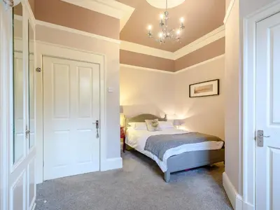 a bedroom with a bed and a chandelier at The Bield in Aberfoyle