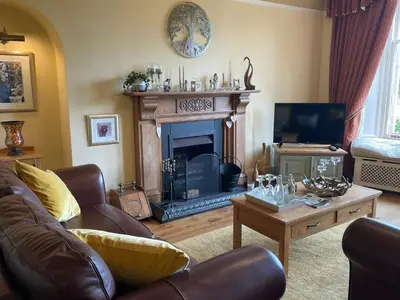 a living room with a couch and a fireplace at The Bield in Aberfoyle