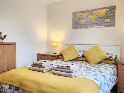 a bedroom with a bed with towels on it at Seven Seasons in Caldercruix
