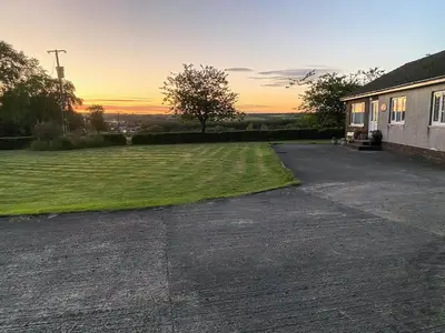 an empty parking lot in front of a house at Seven Seasons in Caldercruix