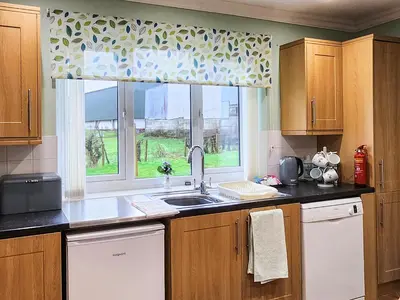 a kitchen with a sink and a window at Seven Seasons in Caldercruix