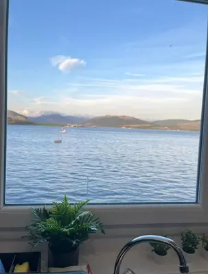 a view of the water from a kitchen window at Beautiful Upper Apartment/Stunning Sea Views, Isle of Bute in Port Bannatyne
