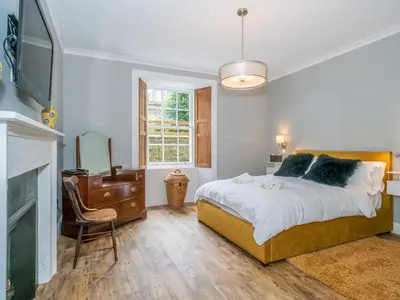 a bedroom with a bed and a tv and a chair at Superb 3Beds House in Chic area of the City Centre - Pass the Keys in Edinburgh