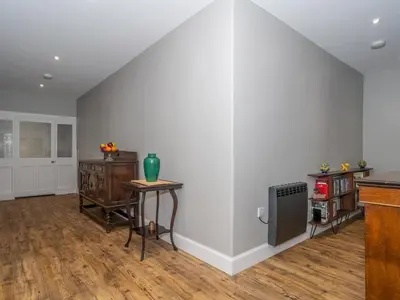 an empty living room with a table and a radiator at Superb 3Beds House in Chic area of the City Centre - Pass the Keys in Edinburgh