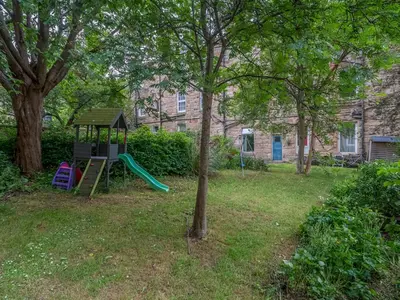 a playground with a slide in a yard at Superb 1 Bed Flat in Traditional Victorian Building - Pass the Keys in Edinburgh