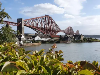 a bridge over a body of water with buildings at Three Bridges Waterfront in North Queensferry