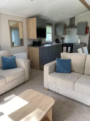 a living room with two couches and a kitchen at Malton 74 in Dunoon