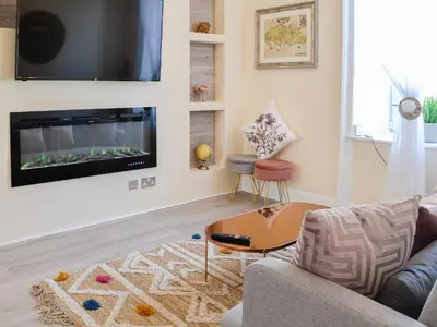 a living room with a couch and a tv on a wall at Cairnsmore - Uk34533 in Newton Stewart