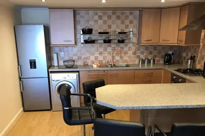 a kitchen with a refrigerator and a counter top at Beautiful 3-Bed Apartment in Gourock in Gourock