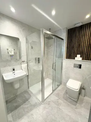 a bathroom with a shower and a toilet and a sink at Sandyford Lodge in Glasgow