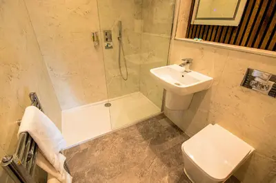 a bathroom with a shower and a sink and a toilet at Sandyford Lodge in Glasgow