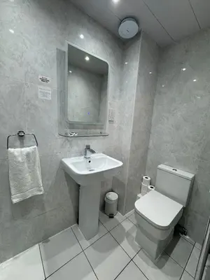 a bathroom with a sink and a toilet and a mirror at Sandyford Lodge in Glasgow