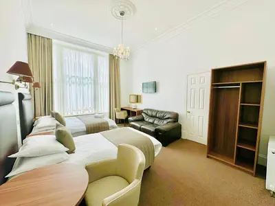 a hotel room with two beds and a couch at Sandyford Lodge in Glasgow