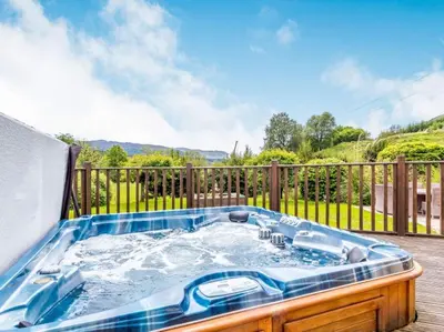 a hot tub sitting on top of a deck at 3 Bedroom luxury home, hot tub, stunning views of Killin, sitting on the River Dochart in Killin