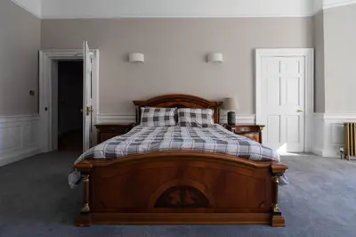 a bedroom with a bed with a plaid blanket on it at Luxury Apartment/Flat Edinburgh City Centre in Edinburgh