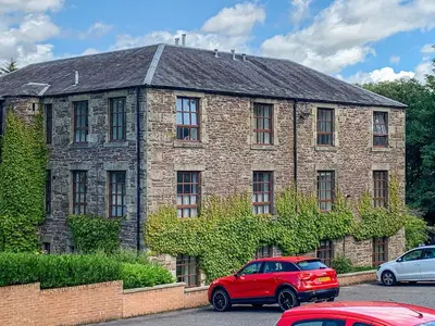 a red car parked in front of a brick building at Mill Court in Dunblane