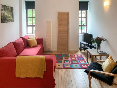 a living room with a red couch and a tv at Mill Court in Dunblane