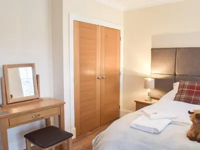 a bedroom with a bed and a desk and a mirror at Dairy Cottage - Uk39522 in Maybole