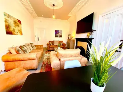 a living room with couches and a table at Historic 2-Bed Paisley Retreat, Airport & Station in Paisley