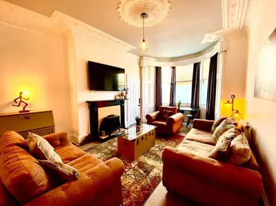 a living room with two couches and a fireplace at Historic 2-Bed Paisley Retreat, Airport & Station in Paisley