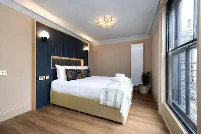 a bedroom with a bed and a large window at 30 Castle Street Aparthotel in Edinburgh