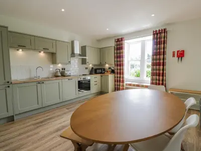a kitchen with a wooden table and a dining room at Garden House - Culzean Castle in Maybole
