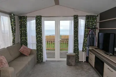 a living room with a couch and a television at Muasdale - Shore View in Muasdale