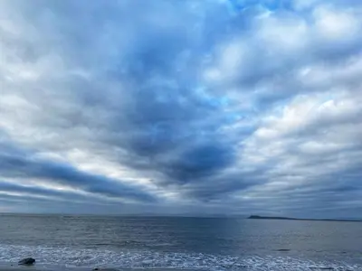 a cloudy sky over the ocean on a beach at Muasdale - Shore View in Muasdale