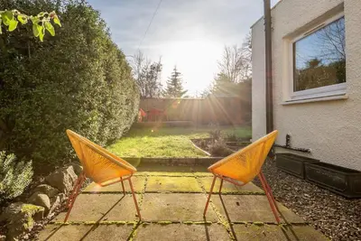 two orange chairs sitting outside of a house at Charming Cardoon Cottage in beautiful village in Comrie