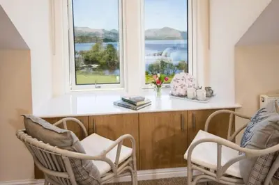 a living room with two chairs and a window at The Old Farmhouse in Balloch