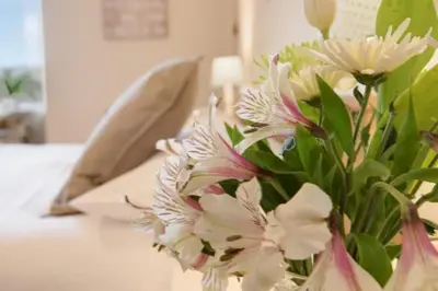 a vase filled with white and pink flowers on a table at The Old Farmhouse in Balloch