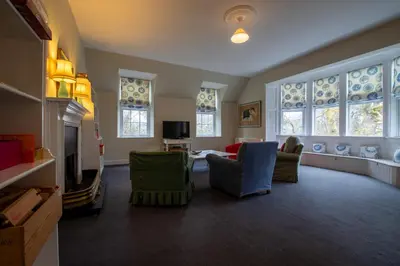 a living room with a couch and chairs and windows at Achnacloich in Achnacloich