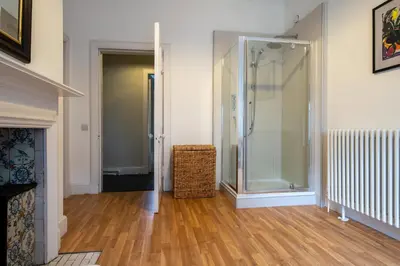 a walk in shower in a room with a wooden floor at Achnacloich in Achnacloich