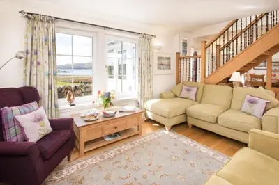 a living room with two couches and a staircase at Ardlarach Lodge in Cullipool