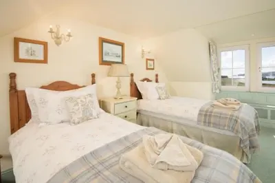a bedroom with two beds and a window at Ardlarach Lodge in Cullipool