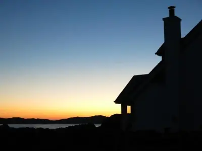 a silhouette of a house with the sunset in the background at Ardlarach Lodge in Cullipool