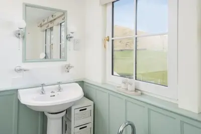 a white bathroom with a sink and a window at Ardlarach Lodge in Cullipool